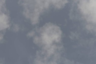 Berrak mavi bir gökyüzü, dağınık, yumuşak beyaz bulutlar, sakin ve sakin bir atmosfer yaratıyor..