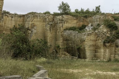 İspanya 'nın Menorca kentindeki Lithica Pedreres de s' Hostal 'daki antik taş ocaklarının büyüleyici manzarası etkileyici taş yapıları ve doğal yeşillikleri gözler önüne seriyor..