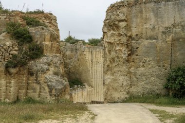 İspanya 'nın Menorca kentindeki Lithica Pedreres de s' Hostal 'daki antik taş ocaklarının büyüleyici manzarası etkileyici taş yapıları ve doğal yeşillikleri gözler önüne seriyor..