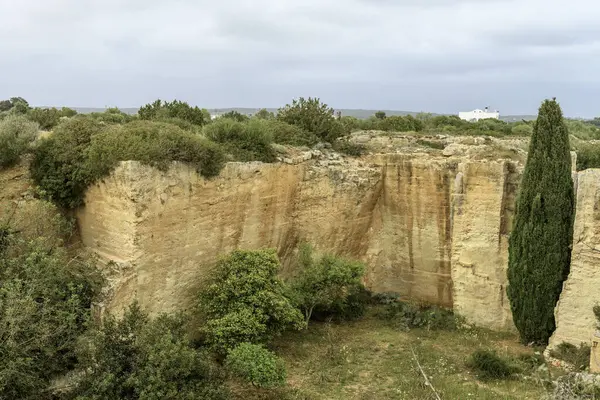 stock image A captivating view of the ancient quarry walls at Lithica Pedreres de s'Hostal in Menorca, Spain, showcasing the impressive stone structures and natural greenery.