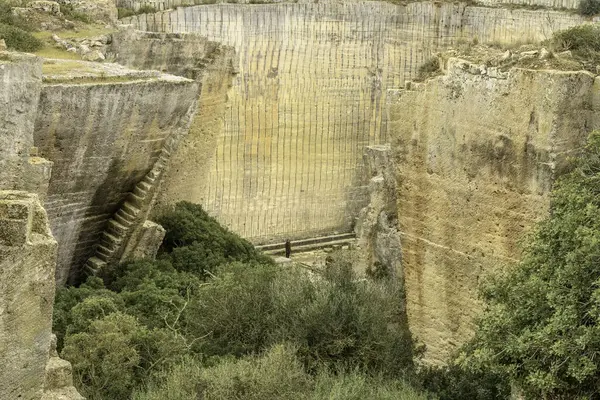 stock image A captivating view of the ancient quarry walls at Lithica Pedreres de s'Hostal in Menorca, Spain, showcasing the impressive stone structures and natural greenery.