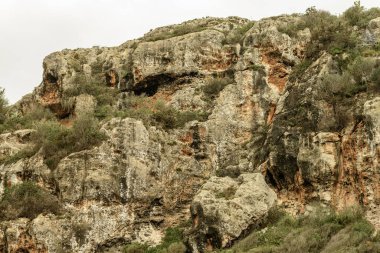 Cala Coves, Menorca 'daki antik nekropolis mağaralarının yakın çekimleri engebeli kaya oluşumlarını ve yemyeşil bitki örtüsünü gözler önüne seriyor. Bu tarihi mağaralar manzaraya gizemli bir cazibe katıyor..
