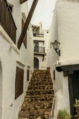 Geleneksel beyazlatılmış evler ve Binibeca Vell, Menorca 'nın dar, dolambaçlı caddelerinin manzarası..