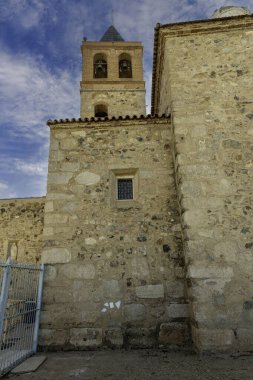 Merida, İspanya 'daki Santa Eulalia Bazilikası' nın çan kulesine yakın plan, tarihi taş mimarisini ve çanlarını açık mavi gökyüzüne karşı sergiliyor..