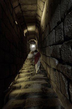 İspanya 'nın Merida kentindeki antik bir yapıya açılan loş bir taş geçit. Engebeli basamaklar ve duvarlar tarihin mimari hünerini sergiliyor.