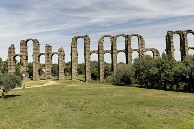 The Roman Aqueduct of Miracles in Merida, Spain, stands tall amidst lush greenery. An ancient marvel showcasing Roman engineering brilliance. clipart