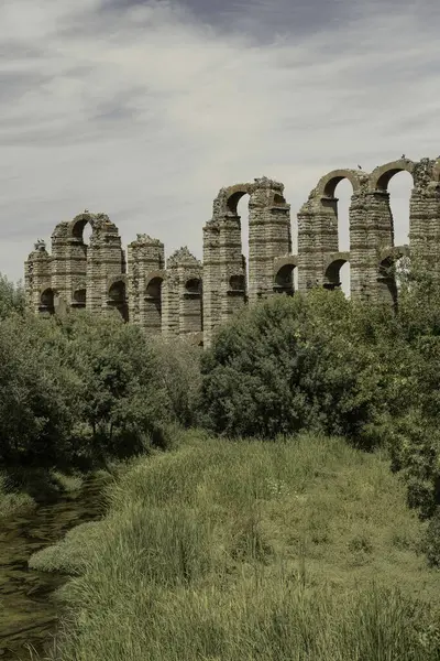 stock image The Roman Aqueduct of Miracles in Merida, Spain, stands tall amidst lush greenery. An ancient marvel showcasing Roman engineering brilliance.