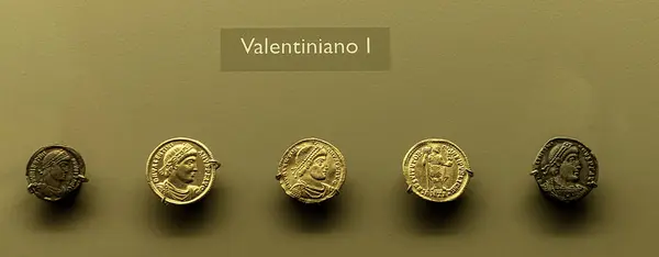 stock image Collection of ancient Roman coins featuring Emperor Valentinian I at the Merida Museum, Spain, showcasing detailed imperial portraiture and historical numismatics.