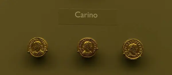 stock image Ancient gold coins featuring Carinus, Roman Emperor, displayed in a museum. Coins show the Emperor's profile with detailed inscriptions.