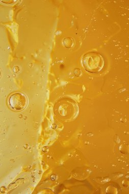 Değişen sarı tonlarında kabarcıklar ve sıvı dokular içeren soyut görüntü dinamik ve canlı bir bileşim oluşturur..