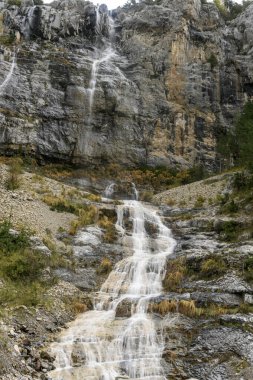 Picturesque high mountain waterfall in the sopeliana ravine in Bujaruelo, in the Ordesa National Park. clipart