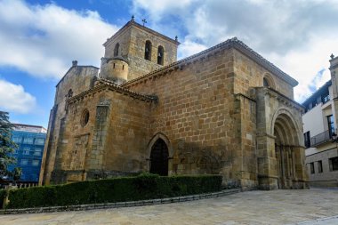 Güzel Roma taştan kilisesi. Karmaşık kemer detayları ve huzurlu bir kentsel alanla çevrili bir çan kulesi var..