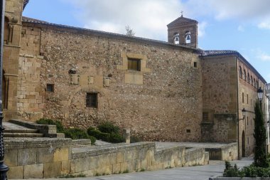Tarihi bir kilisenin görkemli görünüşü. Karmaşık oymalar, bir gül penceresi ve berrak mavi gökyüzünün altında dekoratif kemerler..