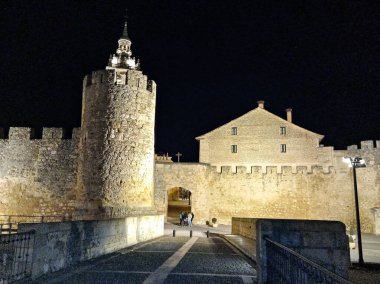 Ortaçağ duvarlarının gece manzarası ve Burgo de Osma 'nın güçlendirilmiş girişi, güzel aydınlatılmış, tarihi mimarisini vurguluyor..