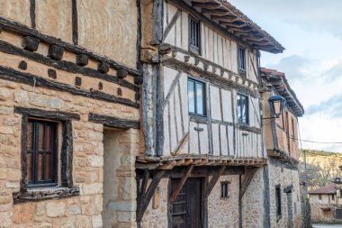 Tarihi bir İspanyol köyünde, taş duvarları ve tahta kirişleri olan geleneksel yarı keresteli bir ev..