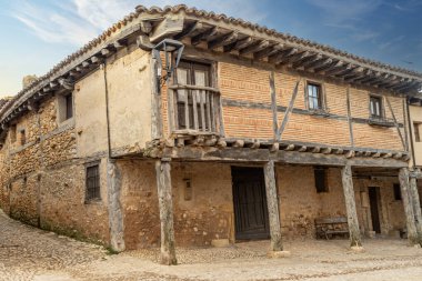 İspanya 'nın Soria kentindeki tarihi bir köyde, taştan duvarları olan geleneksel yarı ahşap evler kaldırım taşından bir cadde üzerindedir..