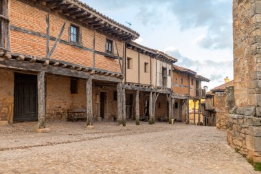 İspanya 'nın Soria kentindeki tarihi bir köyde, taştan duvarları olan geleneksel yarı ahşap evler kaldırım taşından bir cadde üzerindedir..