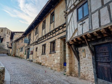 İspanya 'nın Soria kentindeki tarihi bir köyde, taştan duvarları olan geleneksel yarı ahşap evler kaldırım taşından bir cadde üzerindedir..