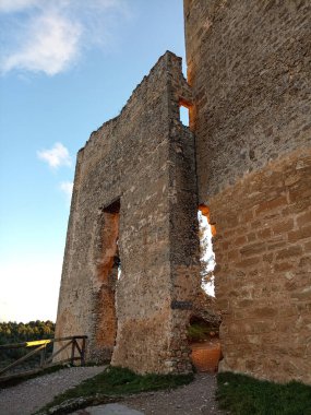 Calataazor Kalesi 'nin yıpranmış taş duvarları, sıcak günbatımı ışığıyla aydınlatılmış, ortaçağ mimari ayrıntılarını gösteriyor..