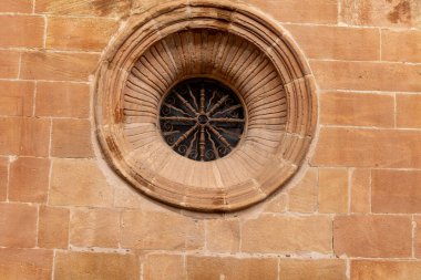 Gomara Kontu, Soria Kontu, İspanya 'nın tarihi sarayında dekoratif demir ızgaralı dairesel taş bir pencerenin yakın çekimi..