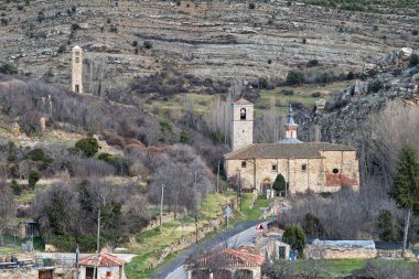 Old stone church in Yanguas, Soria, featuring a bell tower, rustic architecture, and a scenic village setting. clipart