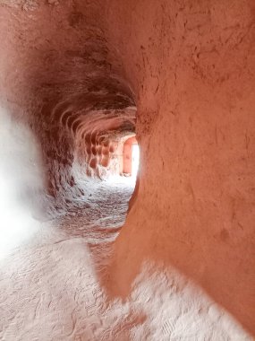 Arnedo, La Rioja, İspanya 'daki Yüz Sütun Mağarası' nın içinde loş bir geçit, pürüzsüz, doğal dokularla oyulmuş kaya duvarlarını ve tünelin sonunda bir ışık kaynağını gösteriyor..