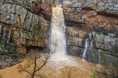 Cascada de la Cimbarra, İspanya 'da baş döndürücü bir şelale, engebeli kayalıkların üzerinden güçlü su akışıyla çağlayarak dramatik bir doğal manzara yaratır..