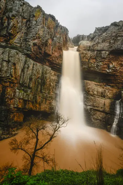 Cascada de la Cimbarra 'nın çarpıcı uzun bir görüntüsü. Suyun kayalık uçurumlarda sorunsuzca aktığı, yemyeşil bitki örtüsü ve dramatik manzaralarla çevrili..