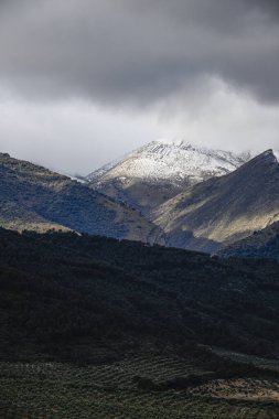 İspanya, Sierra Magina 'nın nefes kesici manzarası, karla kaplı tepeler, yuvarlanan tepeler ve engebeli dağ manzarasını çevreleyen sisli bulutlar..