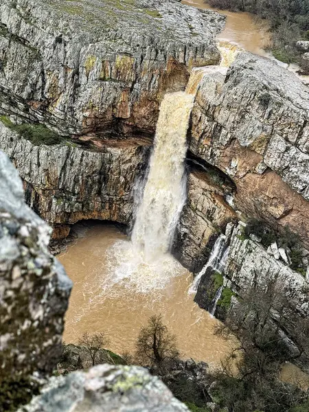 Cascada de la Cimbarra, İspanya 'da baş döndürücü bir şelale, engebeli kayalıkların üzerinden güçlü su akışıyla çağlayarak dramatik bir doğal manzara yaratır..