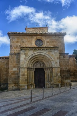 Güzel Roma taştan kilisesi. Karmaşık kemer detayları ve huzurlu bir kentsel alanla çevrili bir çan kulesi var..