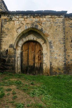 Orman tepeleri ve yeşilliklerle çevrili verimli bir kırsal alanda yenilenmekte olan Romen taş kilisesi.