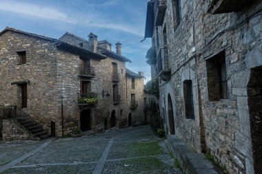 Cobblestone caddesi, temiz gökyüzünün altındaki tarihi bir köyde taştan yapılmış binalarla dolu..