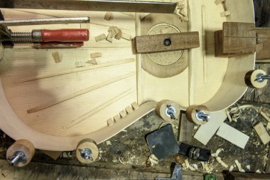 Gitar içerisindeki tel, astar blokları ve çalışma tezgahındaki kıskaçların ayrıntıları