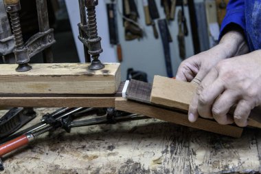 Luthier klasik gitar ensesinde fretboard hizalar ve emniyete alır