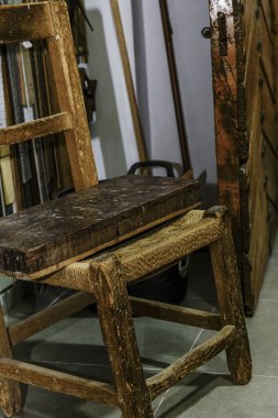 Luthier atölyesinde kullanılan kaba bloklu eski ahşap sandalye.