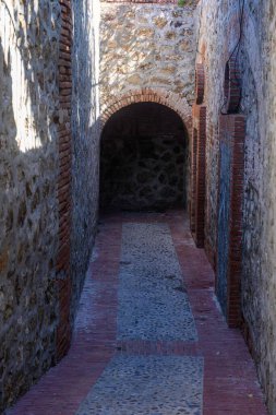 Ceuta 'da Ermita de San Antonio yakınlarında kırmızı tuğlalı taş sokak ve kemerli giriş..