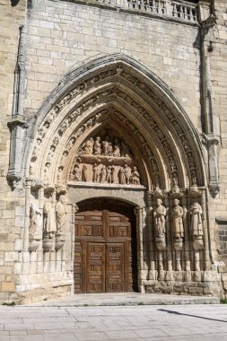 İspanya, Burgos 'ta taş heykeller ve detaylı kabartmalarla süslü gotik kapı.