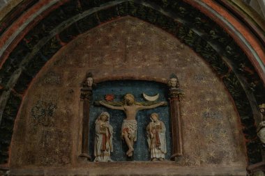 Çarmıha gerilen İsa, Meryem ve Yahya ile birlikte Gotik kemerde Calvary 'nin polikrom rahatlaması.