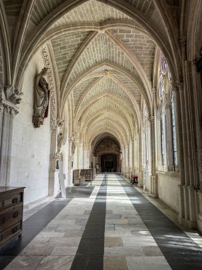 Mozaik cam ve ortaçağ heykelleriyle dolu Gotik manastır galerisi.