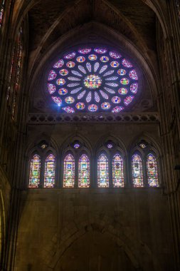 Canlı vitray gül penceresi kilisenin içine renkli bir ışık saçıyor.