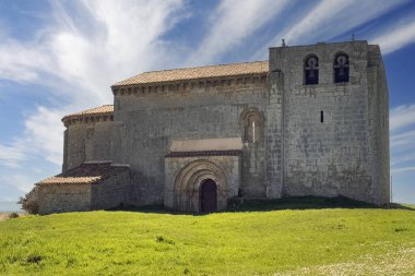 İspanya, Matalbaniega 'da San Martin' in tarihi Roma kilisesi. Taş duvarları ve açık mavi gökyüzünün altında çan kulesi var.