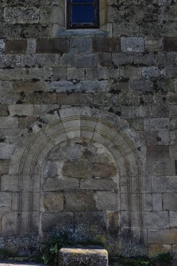Eski bir kilise duvarında eskimiş desenli eski bir taş kemer.