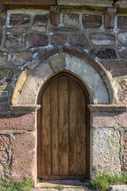 Kırsal kesimlerde kemerli ahşap kapılı eski taş duvar.