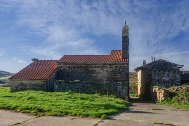 Eski Roma kilisesinde yeşil bir kırsal alanda taş bir çan kapısı ve kiremitli çatısı vardı..