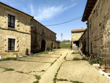 Sakin bir İspanyol köyünde kiremitli çatıları olan eski taş evlerle çevrili dar bir kırsal sokak..