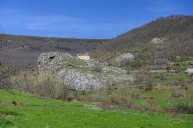 Taş duvarları ve manzaralı dağ manzaralı küçük Roma şapeli..