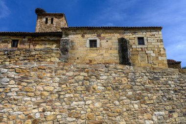 İspanyol köyünde çan kulesi ve kırmızı kiremit çatılı eski taş kilise..