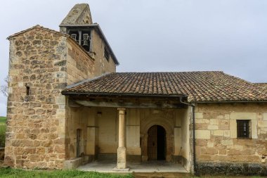 Quintanatello de Ojeda 'da taş duvarları ve kiremitli çatısı olan eski Roma kilisesi.