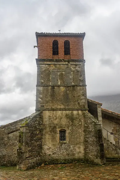 Taştan ve tuğladan yapılmış eski bir kilisede kırsal bir köyde önemli bir çan kulesi var..